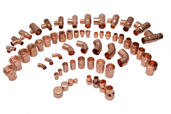 Various copper fittings including elbows, tees, and couplings for plumbing, made from alloy C12200 and compliant with ANSI/ASTM standards